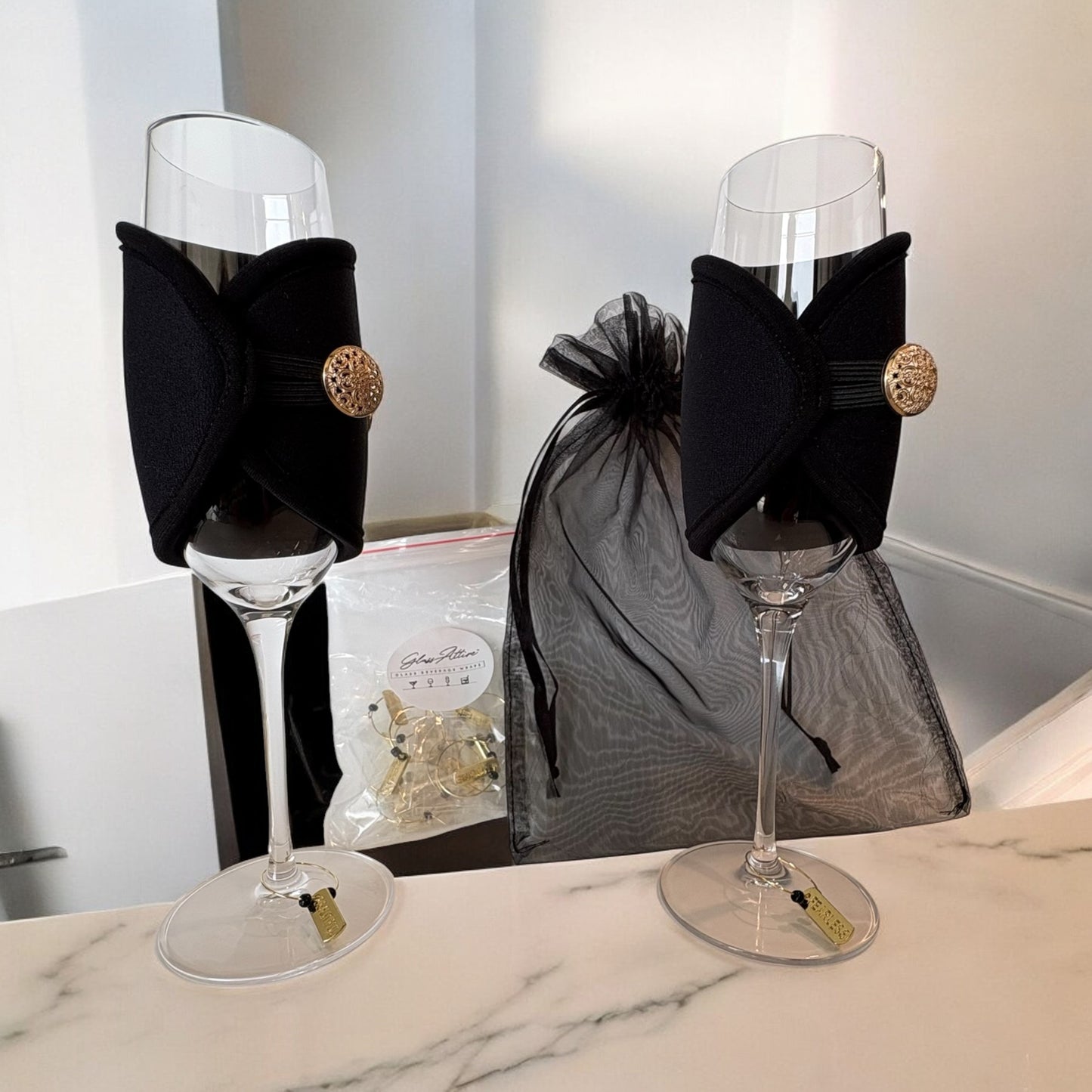 Two wine glasses with decorative black bows on a marble surface.